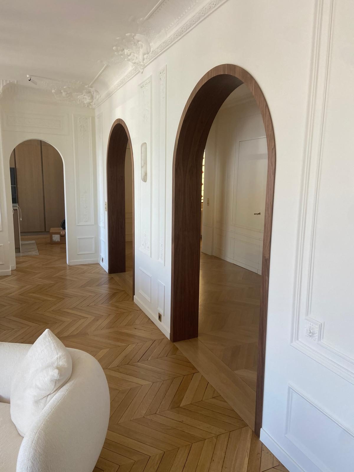 Enfilade d'arches habillées de noyer sur parquet en point de Hongrie