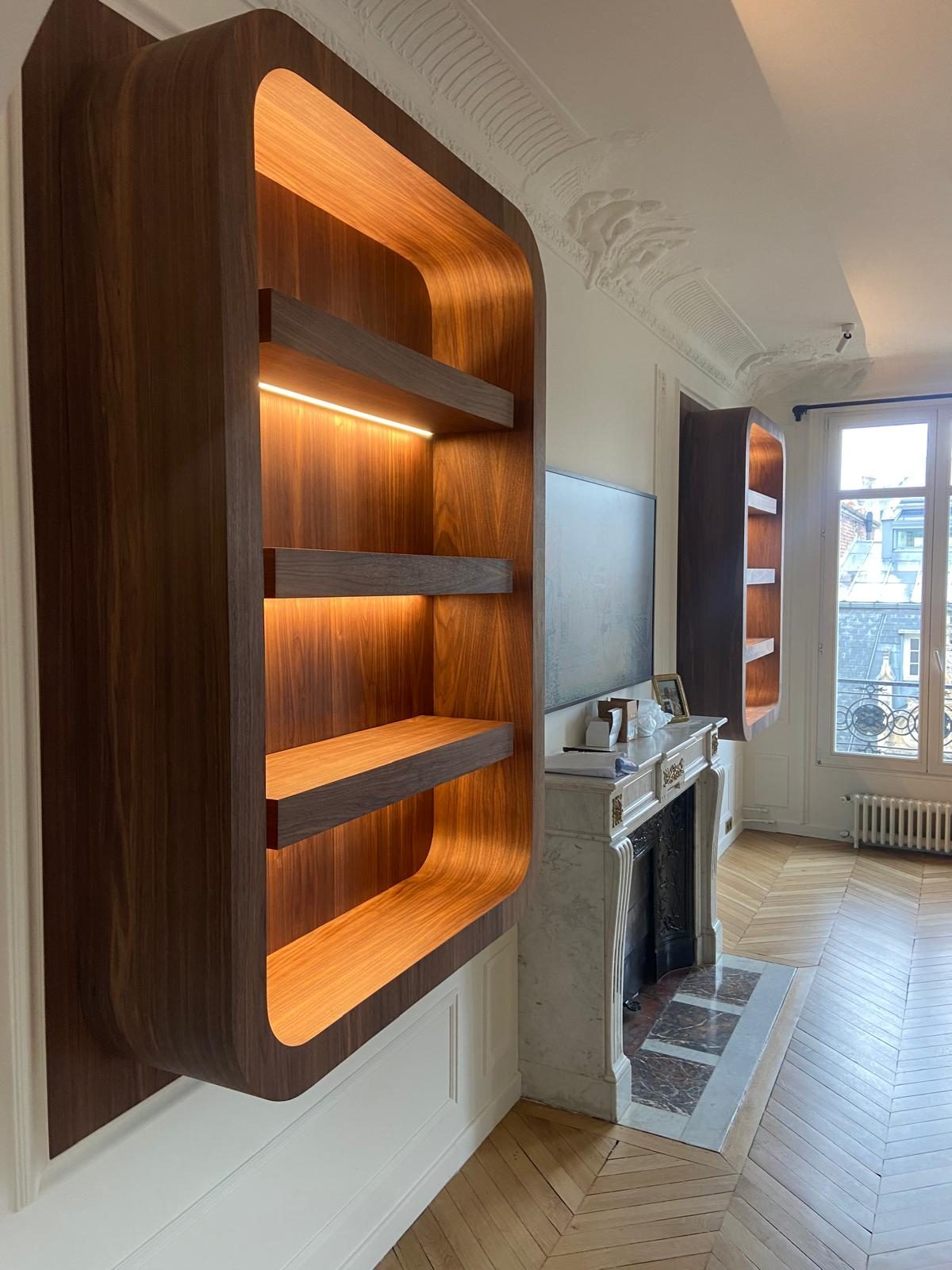 Bibliothèque de niche cintrée en noyer avec éclairage intégré, dans un appartement haussmannien